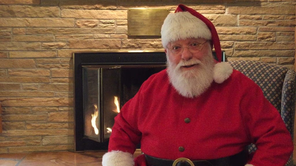 Santa relaxes in front of his fireplace