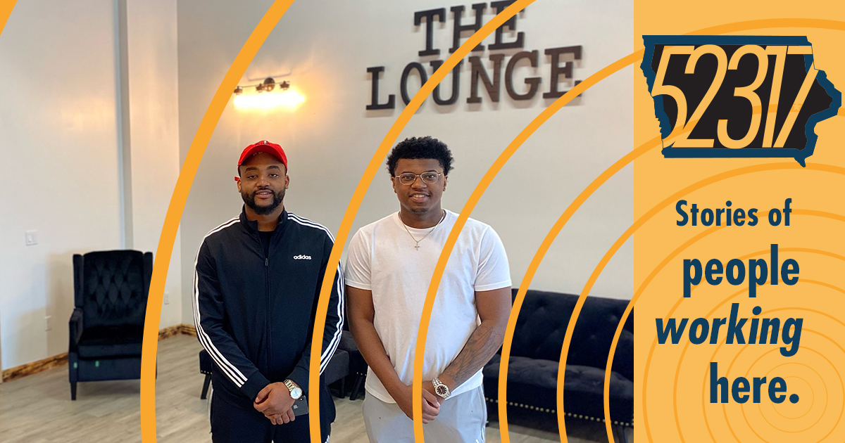 proprietors of the lounge barbershop standing in front of a couch
