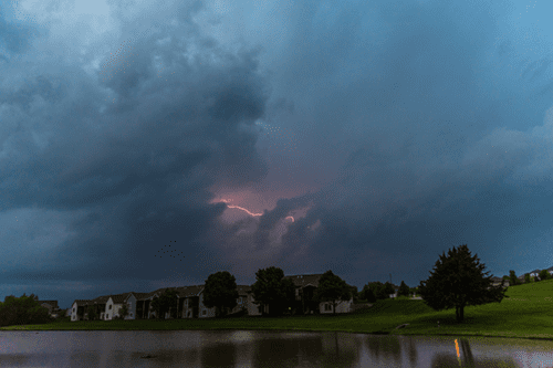 Lightning over homes and a lake in North Liberty by Elizabeth Pearson;