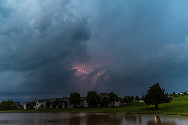 Lightning over homes and a lake in North Liberty by Elizabeth Pearson;