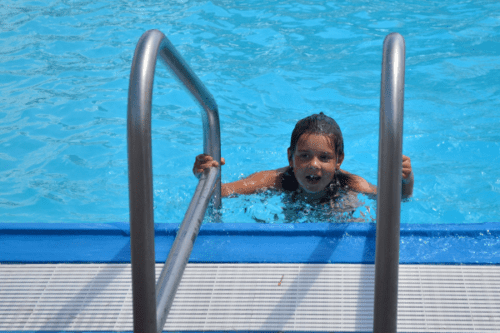 A young swimmer climbs out of the water at the North Liberty outdoor pool.