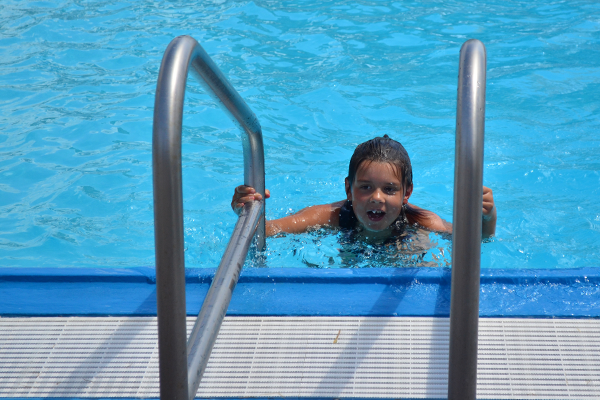 A young swimmer climbs out of the water at the North Liberty outdoor pool.