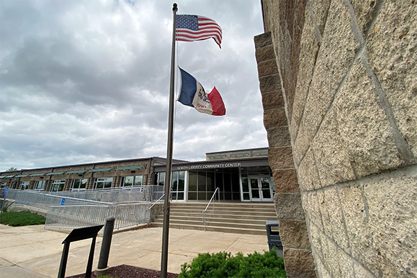 The south face of the Community Center with Iowa and United States flags flying.