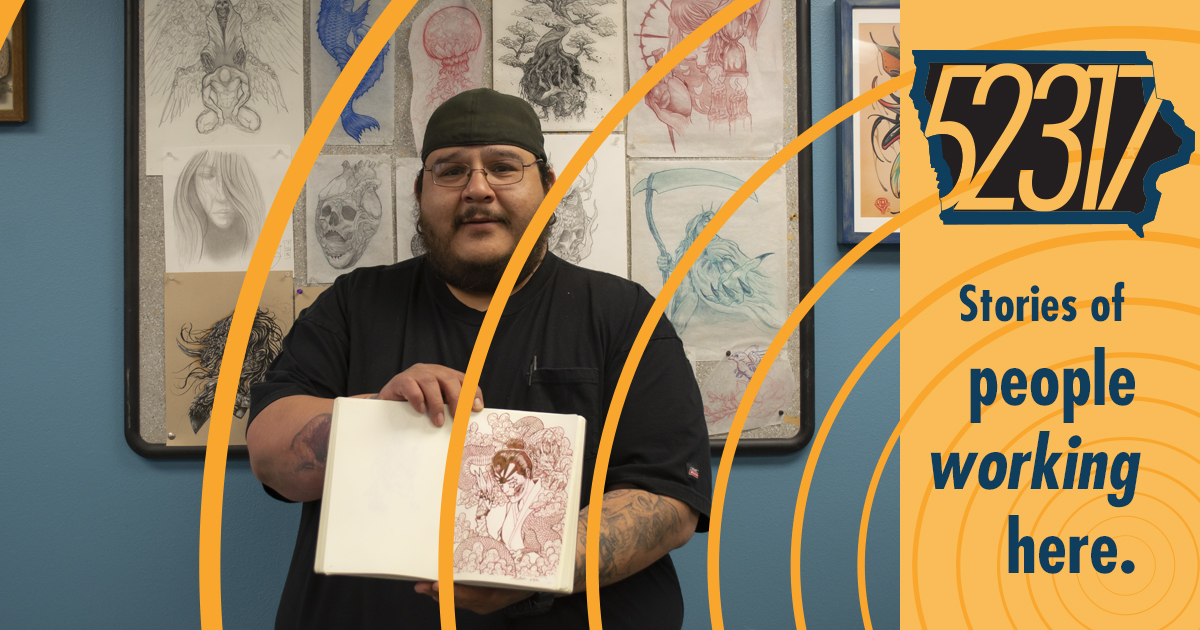 tattoo artist standing amidst his drawings