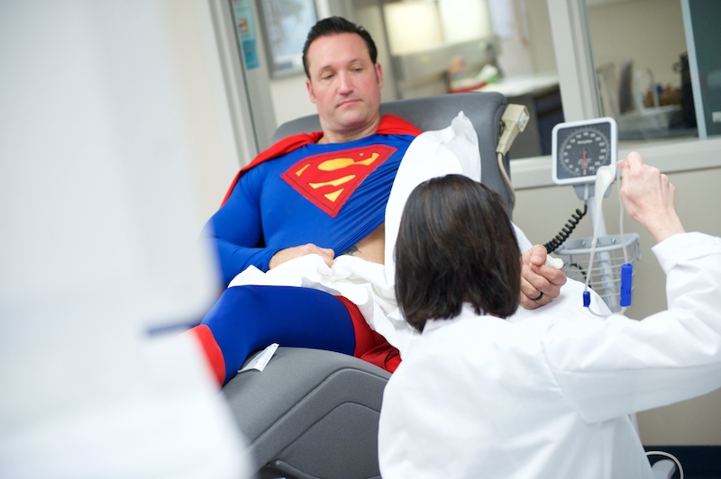A man, dressed as Superman, donates blood