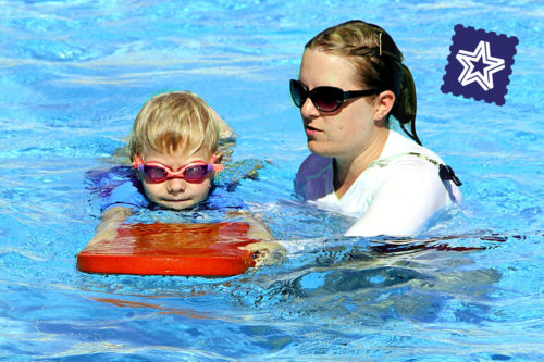 lifeguard teaching child to swim