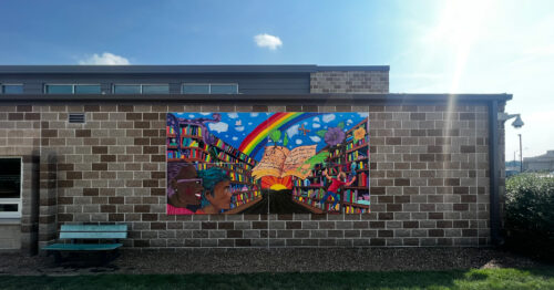 An untitled, portable mural hangs outside the North Liberty Library