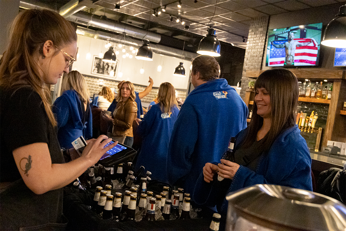 A reveler buys a drink at a local restaurant during the Snuggie Crawl