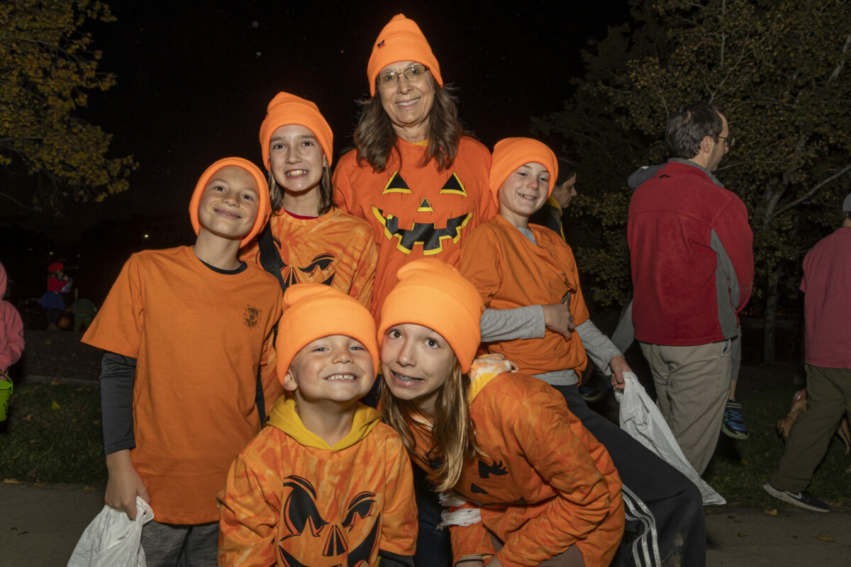 group of smiling people in pumpkin shirts