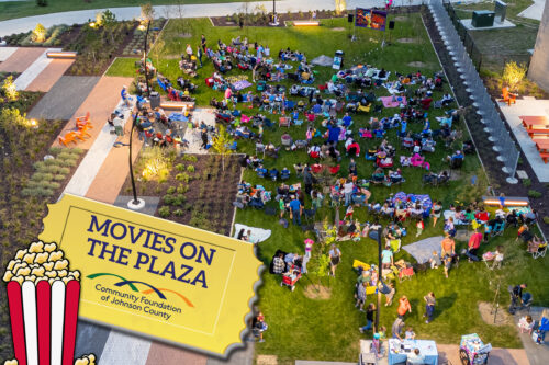 Picture of people sitting on a lawn watching a movie