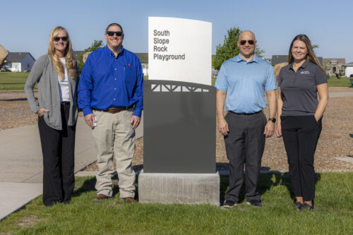 city and south slope staff next to park signage